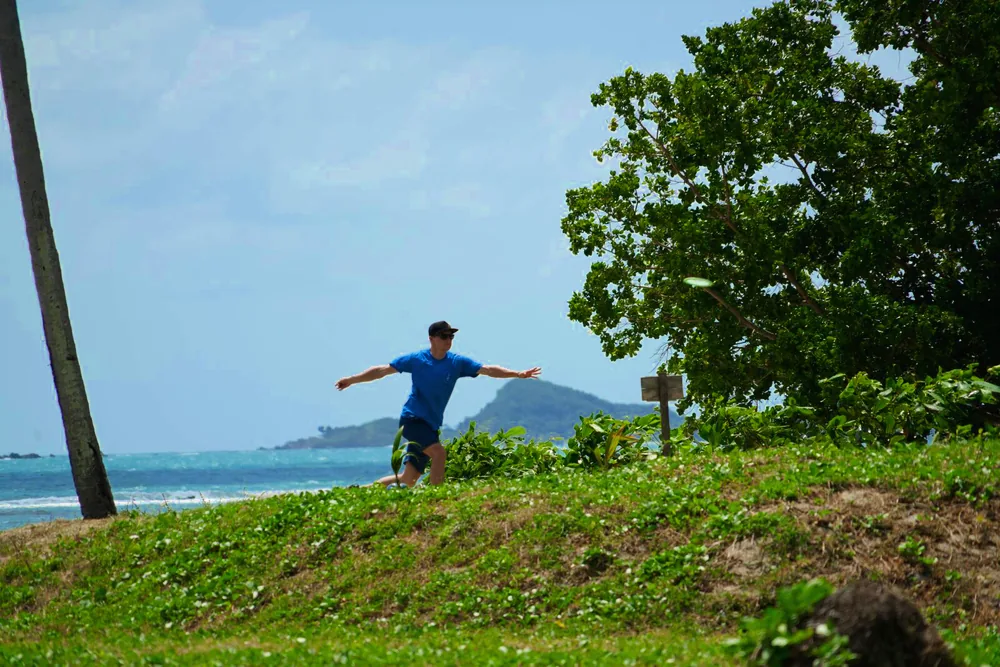 A player throws with the island of Koh Taen behind
