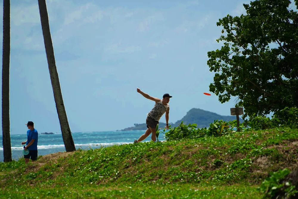 A player drives from the tee toward the sea
