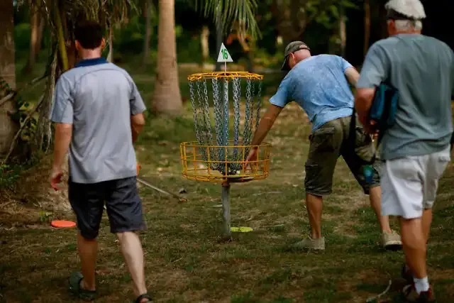 Players gather around the basket to finish a hole