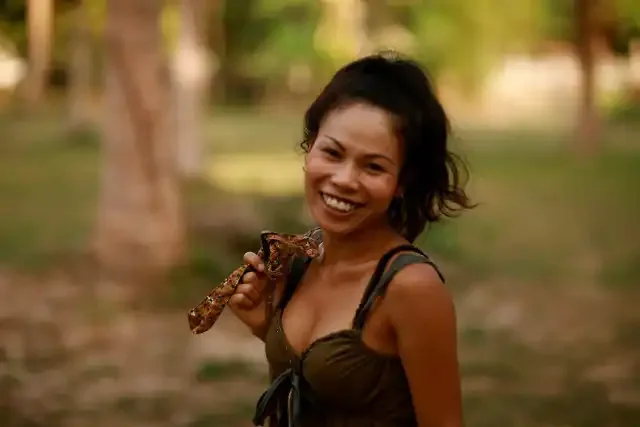 A visitor smiles on the course at golden hour